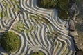 highangle view of a patterned zen garden with rake leaning