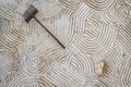 highangle view of a patterned zen garden with rake leaning Royalty Free Stock Photo