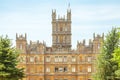 Highclere castle with green trees and blue sky background Newbu