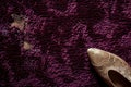 highheeled shoe next to scuff marks on a plush burgundy carpet