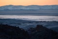 Highland river valley with morning fog on a background of snow covered mountains and glaciers with beautiful sunrise. in the Royalty Free Stock Photo