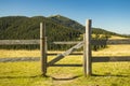 Highland rural scenic view wooden gate palisade paddock fence area with background mountain landscape in summer August day