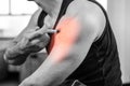 Highlighted arm of strong man injecting anabolic steroid at gym Royalty Free Stock Photo