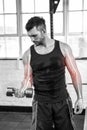 Highlighted arm of strong man lifting weights at gym Royalty Free Stock Photo