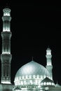 Highlighted white dome and minarets of the mosque against the dark sky.