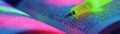 A highlighter pen poised above a textbook ready to emphasize key points in a vibrant splash of color