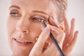 Highlighting her beautiful eyes. A cropped portrait of a beautiful mature woman applying eyeliner. Royalty Free Stock Photo