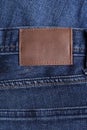 Highly detailed closeup of blank grungy leather label on worn blue denim with orange seams, good for background - Image Royalty Free Stock Photo