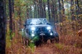 Highly modified Jeep Rubicon off-roading on a trail through woods.