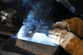 A highly skilled welder welds a metal structure at an assembly plant