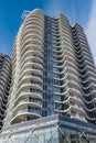 A highrise building against the blue sky. Condominium or apartment building. Looking Up Blue Modern Building