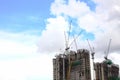 Highrise tower crane and new unfinished residential townhouse under construction, buildings front view. Urban development theme. Royalty Free Stock Photo