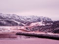 Highway between the Arctic hills. Northern winter road, turn on the road. Magenta polar sunset