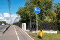 Highway bike lane sign with green foliage and blue sky