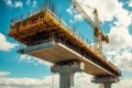 Highway bridge construction site with steel structure, cranes lifting materials against blue sky Royalty Free Stock Photo