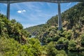 Highway bridge framing wild nature with various types of trees on the banks and Philippine bridge over the ZÃÂªzere river, PORTUGAL Royalty Free Stock Photo
