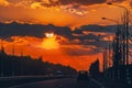 Highway with cars traveling on the sunset. Horizon line with the sun and storm clouds. Journeys. Selective focus Royalty Free Stock Photo