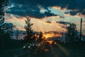 Highway with cars traveling on the sunset. Horizon line with the sun and storm clouds. Journeys. Selective focus Royalty Free Stock Photo