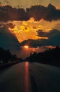 Highway with cars traveling on the sunset. Horizon line with the sun and storm clouds. Journeys. Selective focus Royalty Free Stock Photo