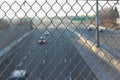 A highway with a chain link fence in the foreground