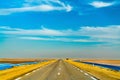 Highway through Chott el Djerid, a dry lake in Tunisia Royalty Free Stock Photo