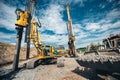 Highway construction with heavy duty machinery. Two Rotary drills, bulldozer and excavator working Royalty Free Stock Photo