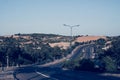 Highway curve road overpass nature landscape background dark tone mist day time street tall lanterns trees bushes Royalty Free Stock Photo