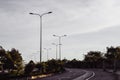 Highway curve road overpass nature landscape background dark tone mist day time street tall lanterns trees bushes Royalty Free Stock Photo