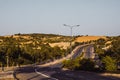 Highway curve road overpass nature landscape background dark tone mist day time street tall lanterns trees bushes Royalty Free Stock Photo