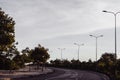 Highway curve road overpass nature landscape background dark tone mist day time street tall lanterns trees bushes Royalty Free Stock Photo