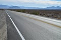 Highway in Death Valley desert blue mountain range Royalty Free Stock Photo