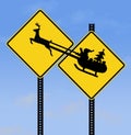 A highway deer crossing warning sign is next to a. similar sign of Santa and his sleigh