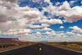 Highway through the deserts under the cloudy sky Royalty Free Stock Photo