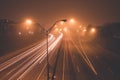 Highway at foggy night with bright trails of light Royalty Free Stock Photo