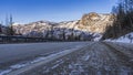 The highway goes forward, towards the sunlit mountains.