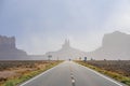 Highway leading towards geological features in Monument Valley desert Royalty Free Stock Photo