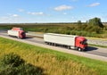 Highway with Lots of semi-trailer trucks . Big lorry traffic on the road. Truck driving along on roadway overtakes another truck.