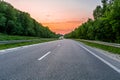 Highway in the middle of the forest belt at sunset Royalty Free Stock Photo