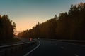 Highway in the middle of the forest in the sunset light Royalty Free Stock Photo