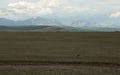 Highway and the Mongolian steppe on a background of mountains of the Eastern Sayan.