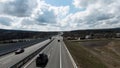 Highway outside the city, panoramic view from above with driving cars. Shot. Straight highway stretching along fields Royalty Free Stock Photo