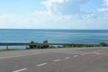 Highway road goes down in mountains with sea view in sunny day. Royalty Free Stock Photo