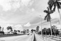 Highway or roadway with cars and skyline of miami, usa. Road with traffic signs for transport vehicles and palm trees on