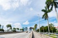 Highway or roadway with cars and skyline of miami, usa. Road with traffic signs for transport vehicles and palm trees on cloudy bl Royalty Free Stock Photo