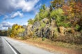 Highway with scenic autumn maple trees on the rocks along the road in Vermont Royalty Free Stock Photo