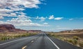 Long highway in the american desert, blue cloudy sky background