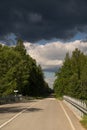 Highway to hell. Car road, bridge and clouds of storm, natural environment background.