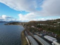 highway and train crossing a wide river with mountain range in the background