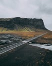 Highway in a valley with a river surrounded by rocks covered in greenery under a cloudy sky Royalty Free Stock Photo