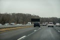 Highway view of cars passing an black electronic sign that is empty and has no message.